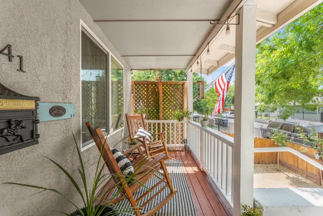 a kitchen with a sink dishwasher a stove and white cabinets with wooden floor