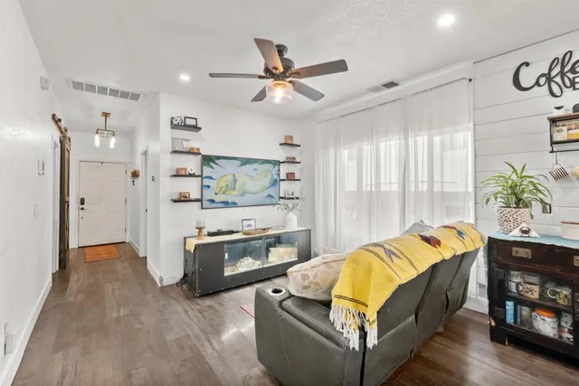 a living room with furniture kitchen view and a window