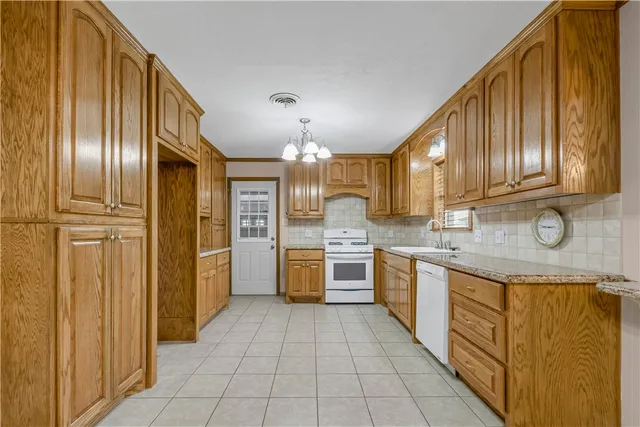 a large kitchen with stainless steel appliances granite countertop a refrigerator and a sink