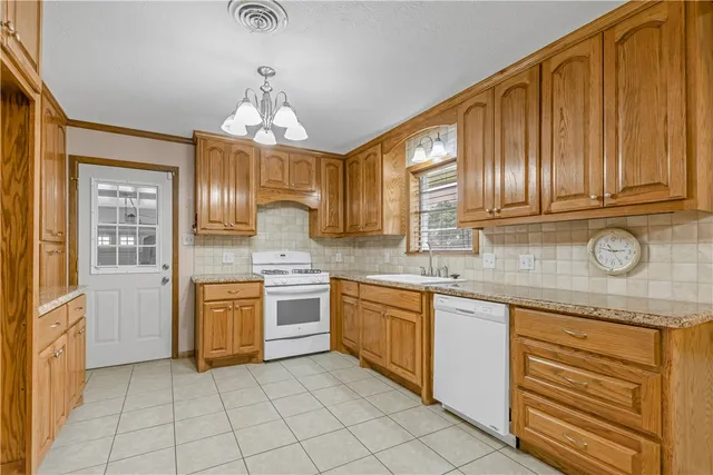a kitchen with granite countertop stainless steel appliances sink cabinets and window