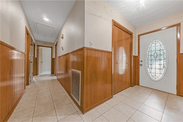 a view of a hallway with windows and chandelier
