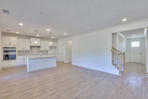 a large kitchen with stainless steel appliances kitchen island a large counter top and a wooden floors