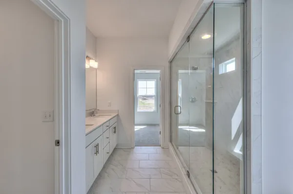 a bathroom with a glass shower door and a sink