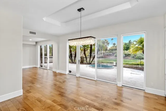 a view of an empty room with glass door and windows