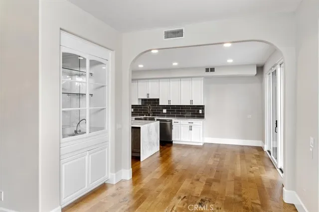 a kitchen with white cabinets and appliances