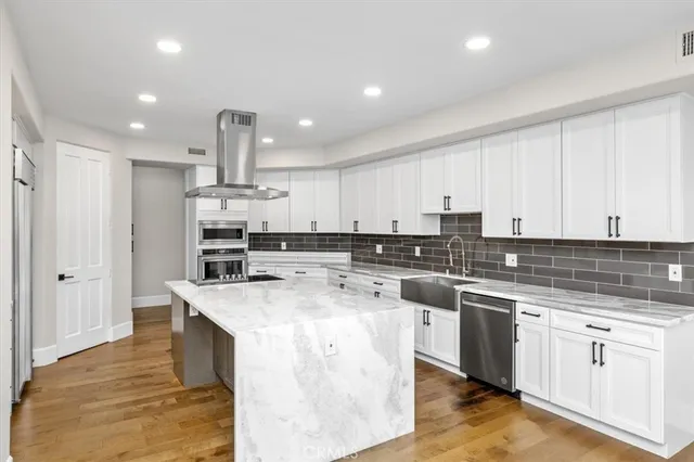 a kitchen with a sink a stove a refrigerator and white cabinets