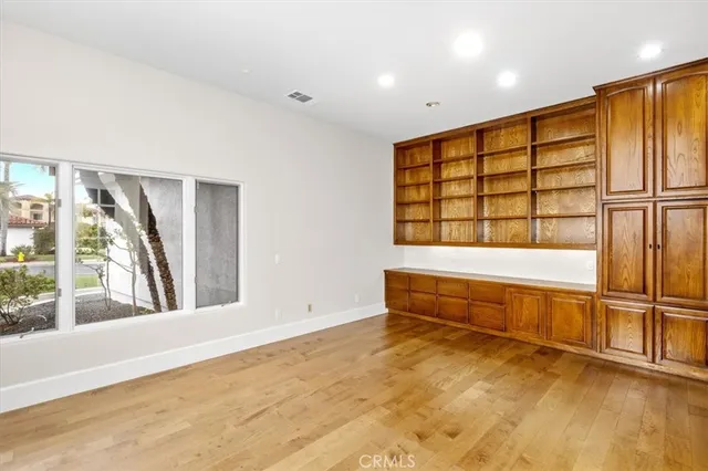 an empty room with wooden floor and a window