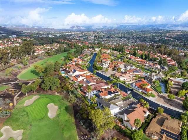 an aerial view of a city with lots of residential buildings ocean and mountain view in back