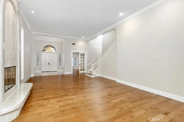 a view of an empty room with window and wooden floor