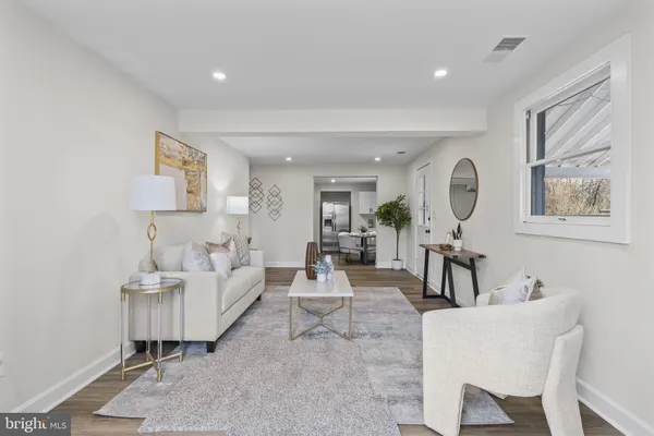 a kitchen with stainless steel appliances granite countertop a stove a sink dishwasher and white cabinets with wooden floor