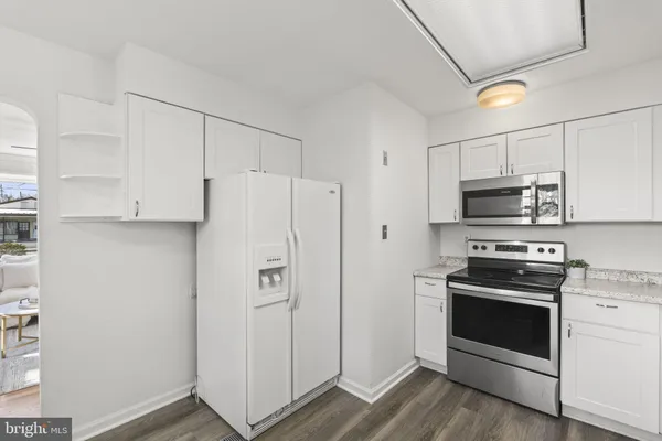 a view of a kitchen with wooden floor and a window