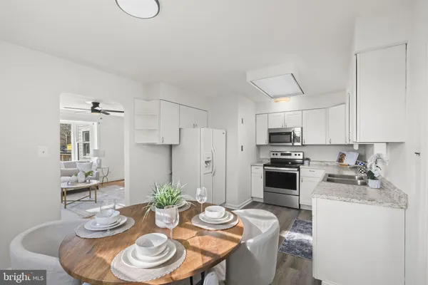 a kitchen with stainless steel appliances a dining table and chairs
