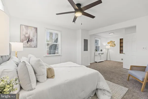 a bedroom with a large bed and a ceiling fan