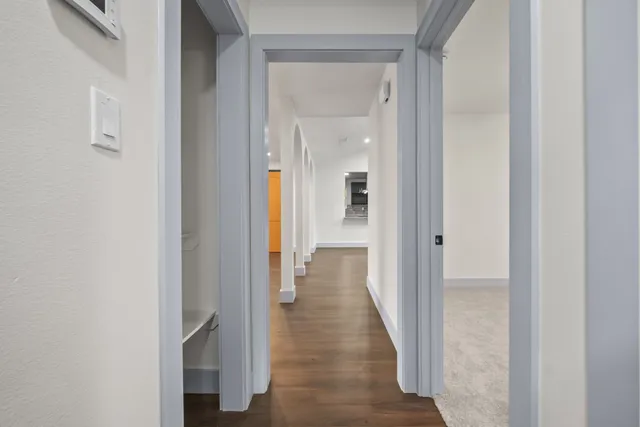a view of a hallway with wooden floor and closet