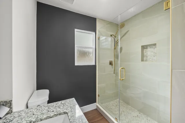 a bathroom with a granite countertop sink a shower and a mirror