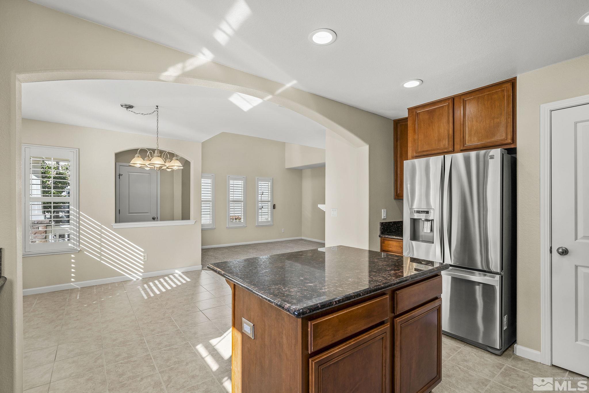 7688 Stone Bluff Way Reno, NV 89523 - Photo 11 of 26 an open kitchen with granite countertop a refrigerator a stove and a sink with wooden floor
