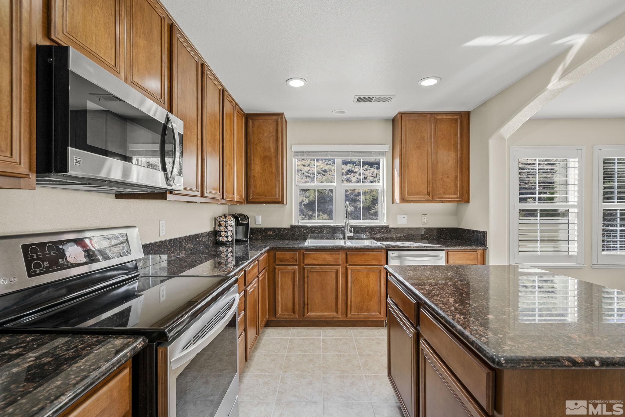 7688 Stone Bluff Way Reno, NV 89523 - Photo 12 of 26 a kitchen with stainless steel appliances granite countertop a stove sink and microwave