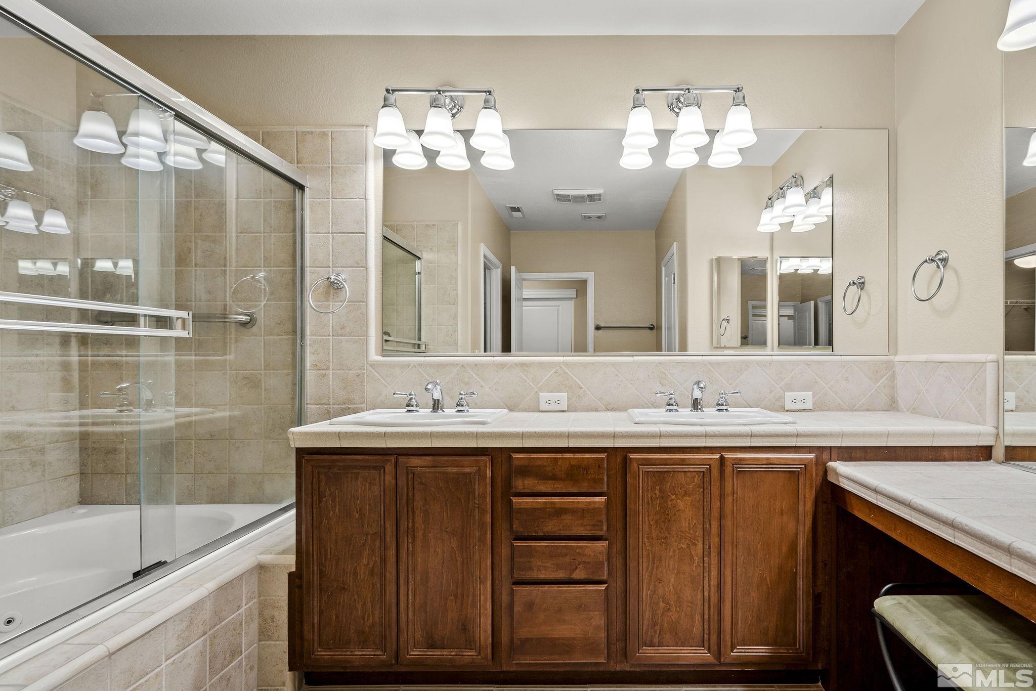 7688 Stone Bluff Way Reno, NV 89523 - Photo 15 of 26 a bathroom with a sink double vanity granite tub and a mirror
