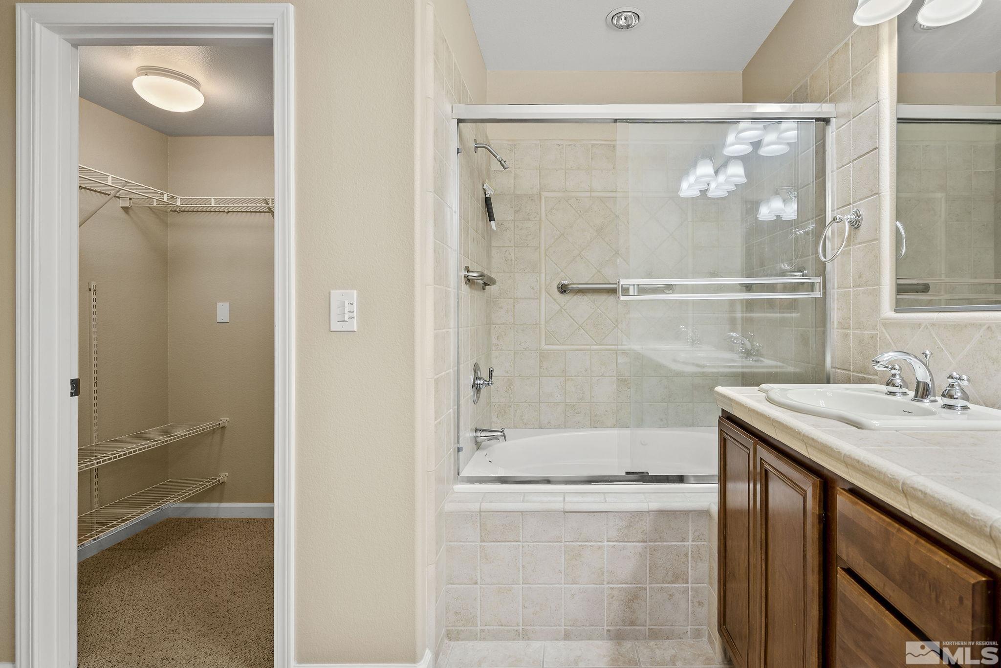 7688 Stone Bluff Way Reno, NV 89523 - Photo 16 of 26 a bathroom with a granite countertop sink mirror and shower