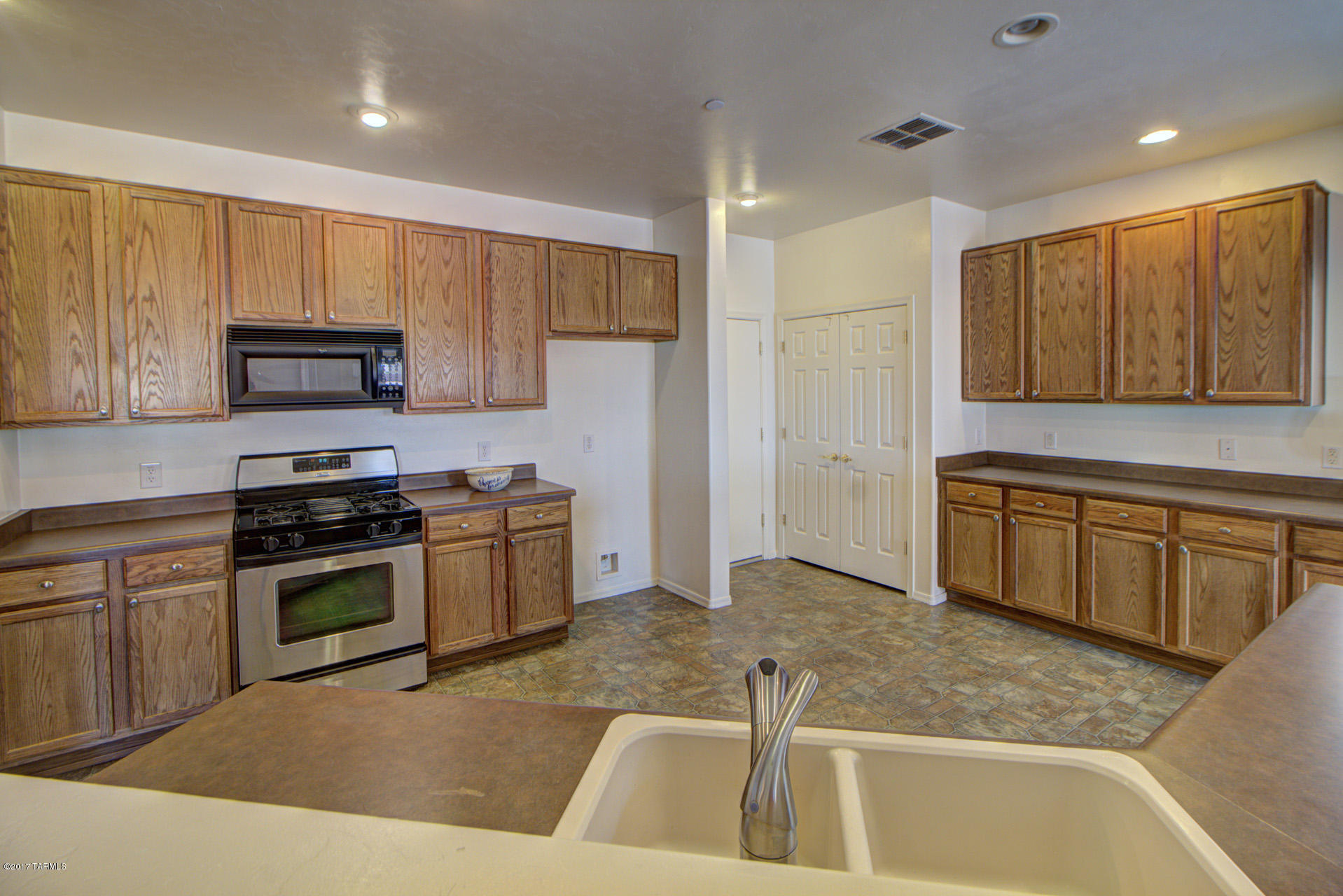 3588 East Mecate Road Tucson, AZ 85739 - Photo 9 of 36 a kitchen with stainless steel appliances granite countertop a stove a sink and a microwave