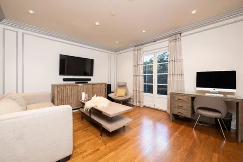 a bedroom with a bed and a dresser with wooden floor