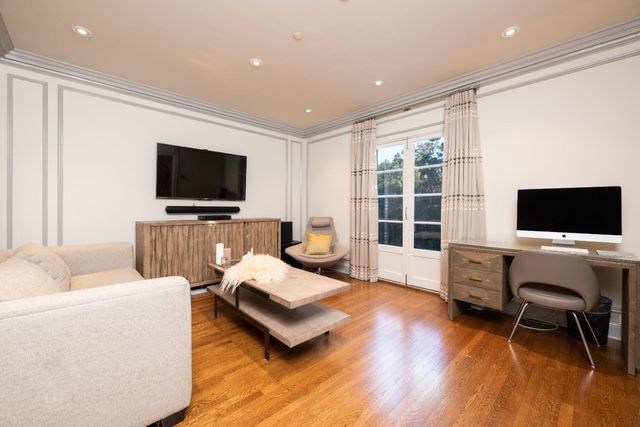 a bedroom with a bed and a dresser with wooden floor