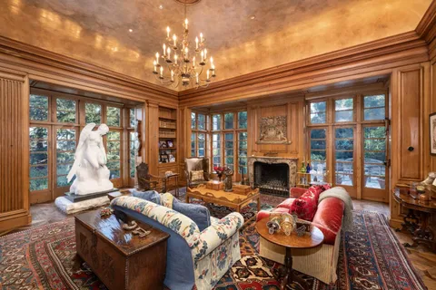 a living room with furniture a chandelier and a fireplace