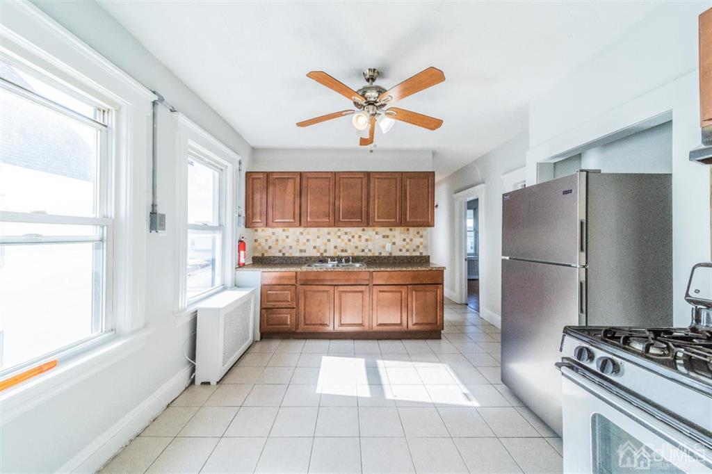 125 Lowell Street, Unit 2 Carteret, NJ 07008 - Photo 6 of 12 a kitchen with stainless steel appliances a refrigerator a stove a sink and a window
