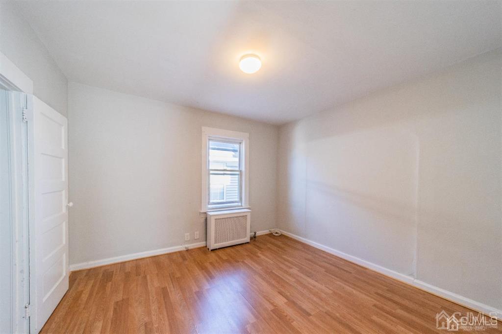125 Lowell Street, Unit 2 Carteret, NJ 07008 - Photo 7 of 12 an empty room with wooden floor and windows