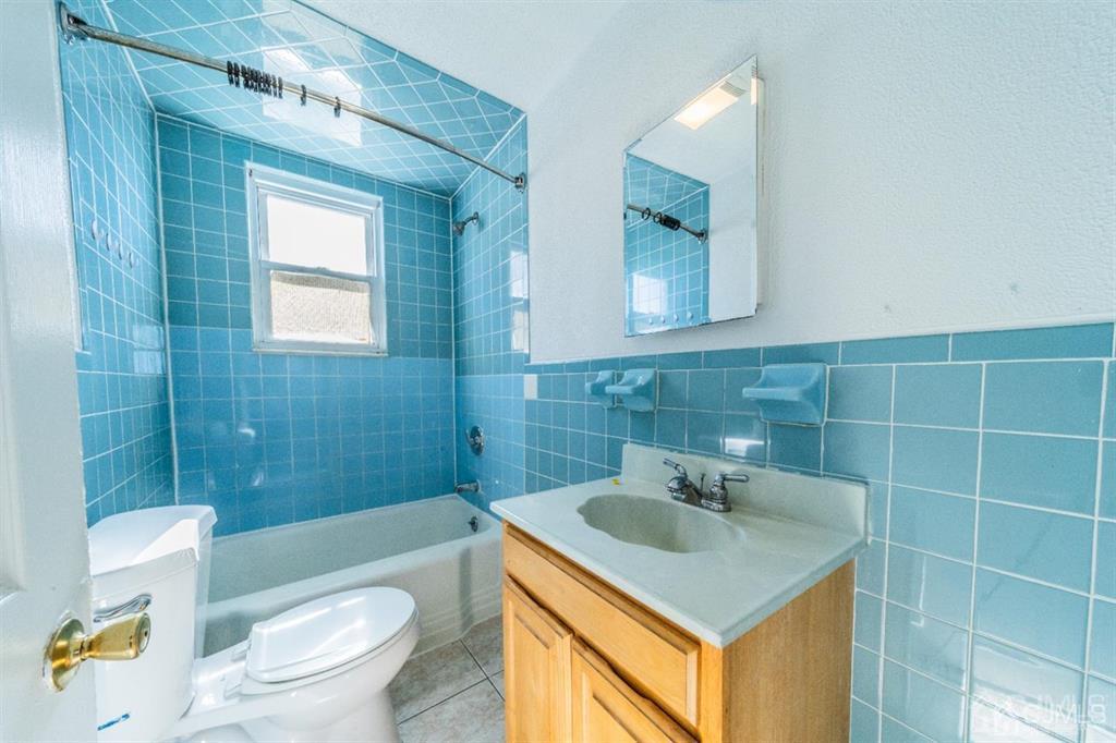 125 Lowell Street, Unit 2 Carteret, NJ 07008 - Photo 9 of 12 a bathroom with a sink a toilet and shower