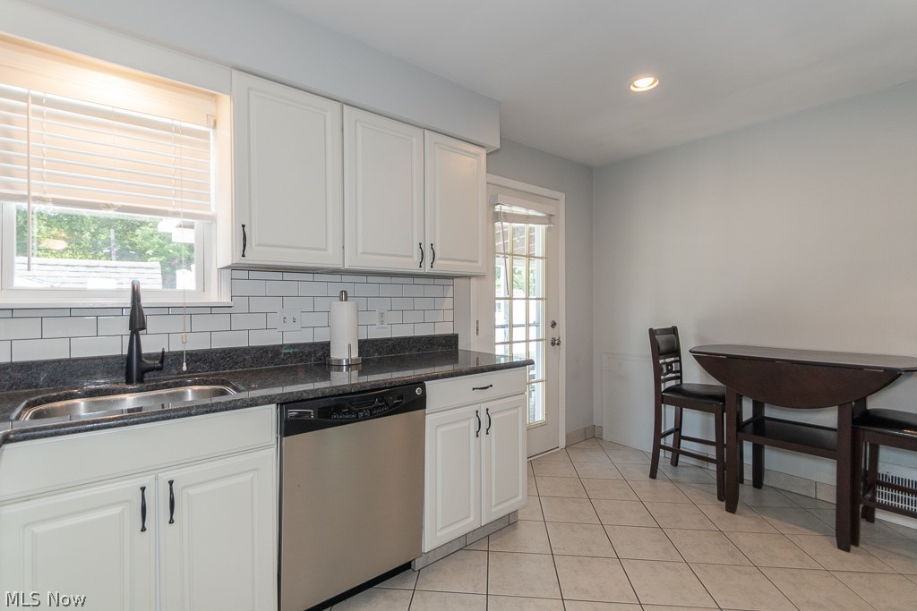 1314 Mayfield Ridge Road Cleveland, OH 44124 - Photo 11 of 40 Kitchen featuring dishwasher, a wealth of natural light, white cabinets, and backsplash