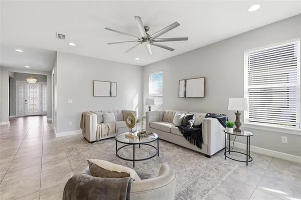 a living room with furniture kitchen view and a chandelier