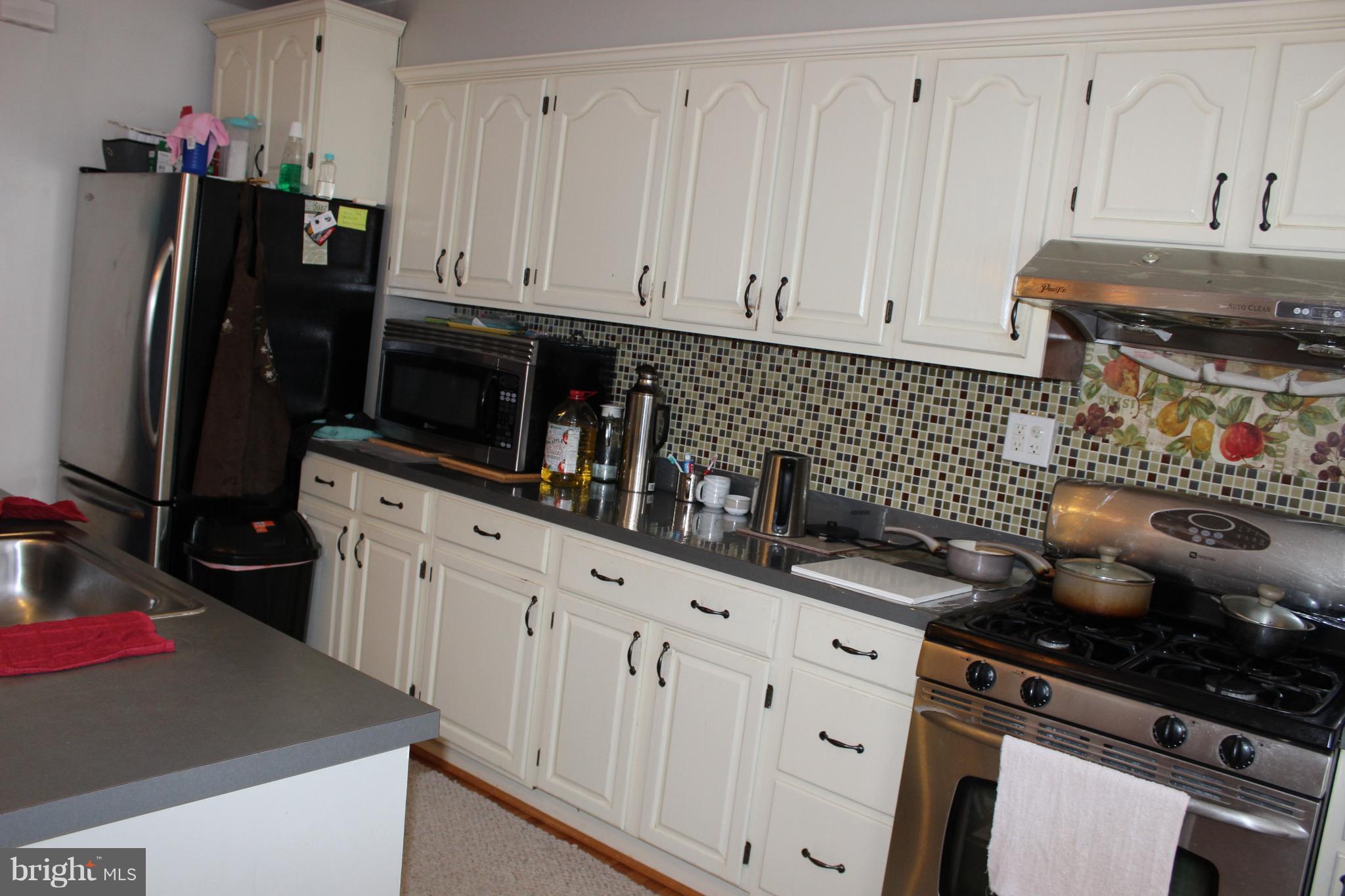 214 Mt De Sales Road Baltimore, MD 21229 - Photo 9 of 29 a kitchen with granite countertop a stove sink and cabinets