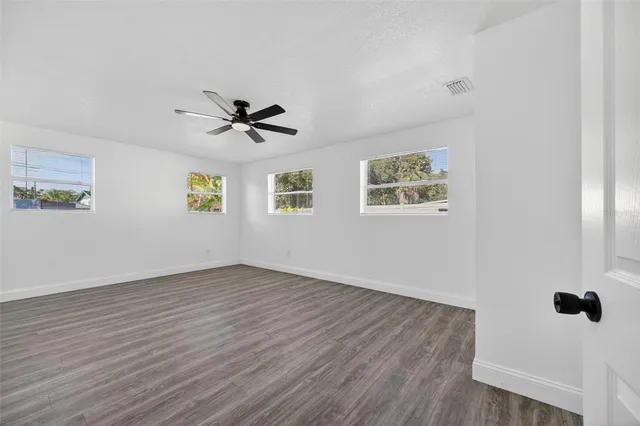 an aerial view of residential houses with outdoor space and trees