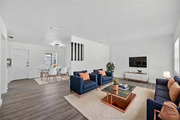 a view of a room with wooden floor and ceiling fan