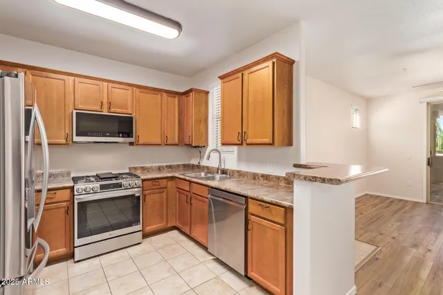 a kitchen with stainless steel appliances granite countertop a refrigerator and a stove top oven