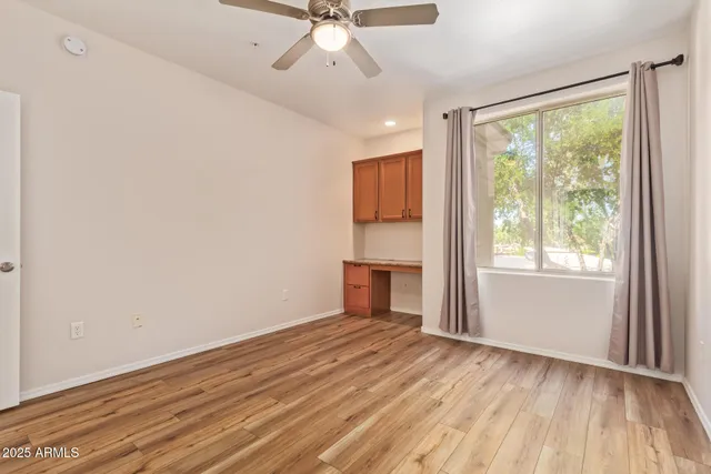 a view of empty room with wooden floor and window