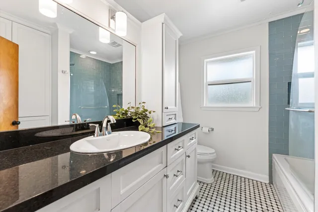 a bathroom with a sink a toilet a shower and a mirror