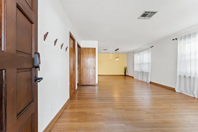 a view of a hallway with wooden floor