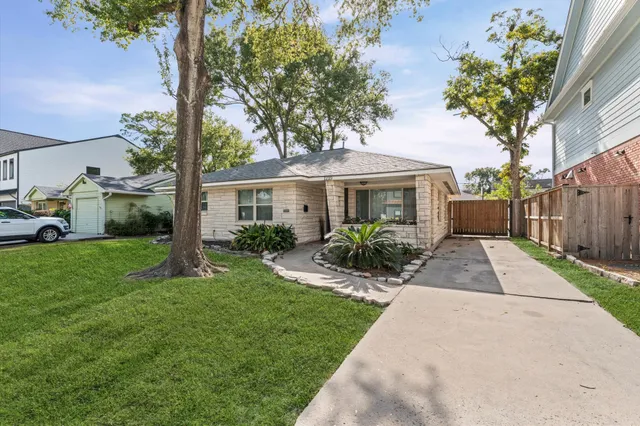 a front view of a house with a yard and trees