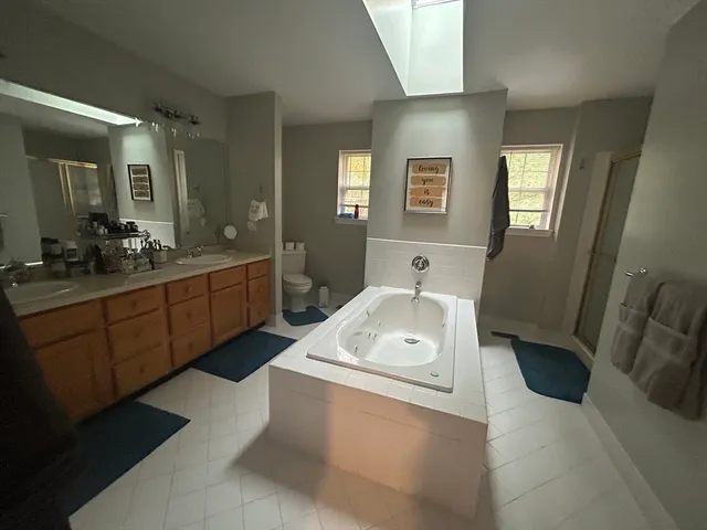 a bathroom with a tub sink and mirror