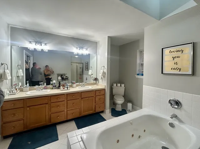 a bathroom with a tub a sink and mirror