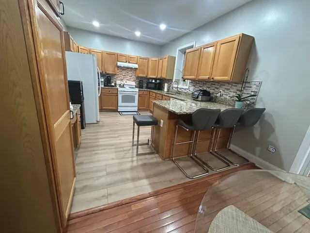 a kitchen with stainless steel appliances granite countertop a refrigerator and a stove top oven