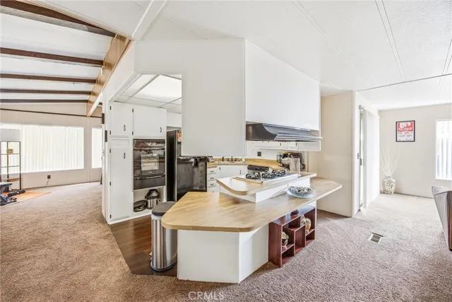a view of a kitchen with stainless steel appliances granite countertop a stove and a refrigerator