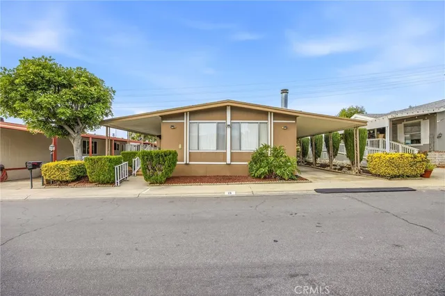 a front view of a house with a yard and potted plants