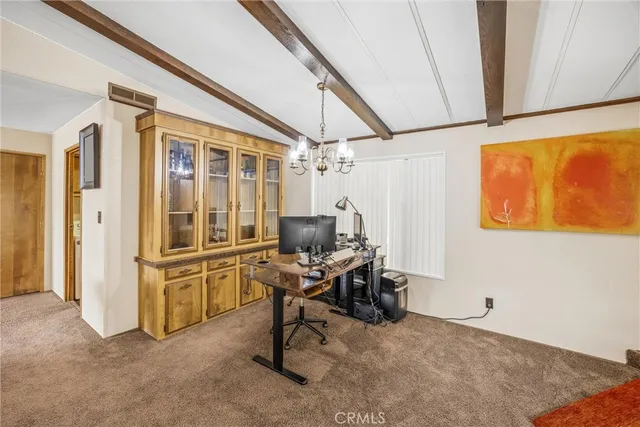 a view of a workspace with furniture and a window