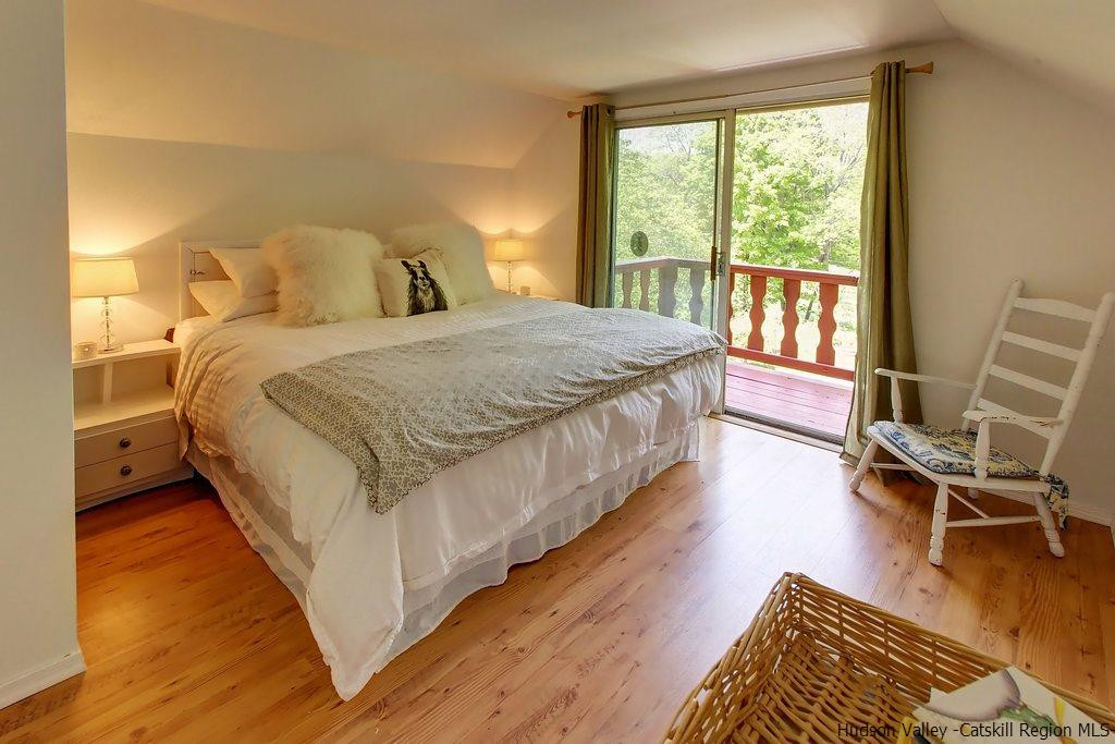 705 Henry Williams Road Roxbury, NY 12474 - Photo 20 of 34 a spacious bedroom with a bed a chair and a large window