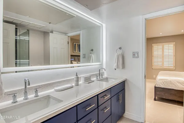 a bathroom with double vanity sinks and a mirror