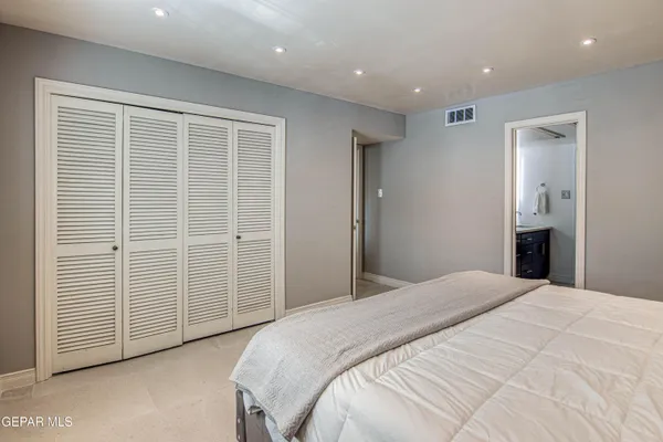 a spacious bedroom with a bed and a walk in closet