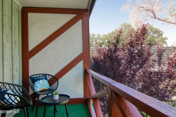 a balcony view with chairs and wooden floor